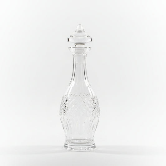 Clear glass vase on a wooden surface with ornate metal objects in the background