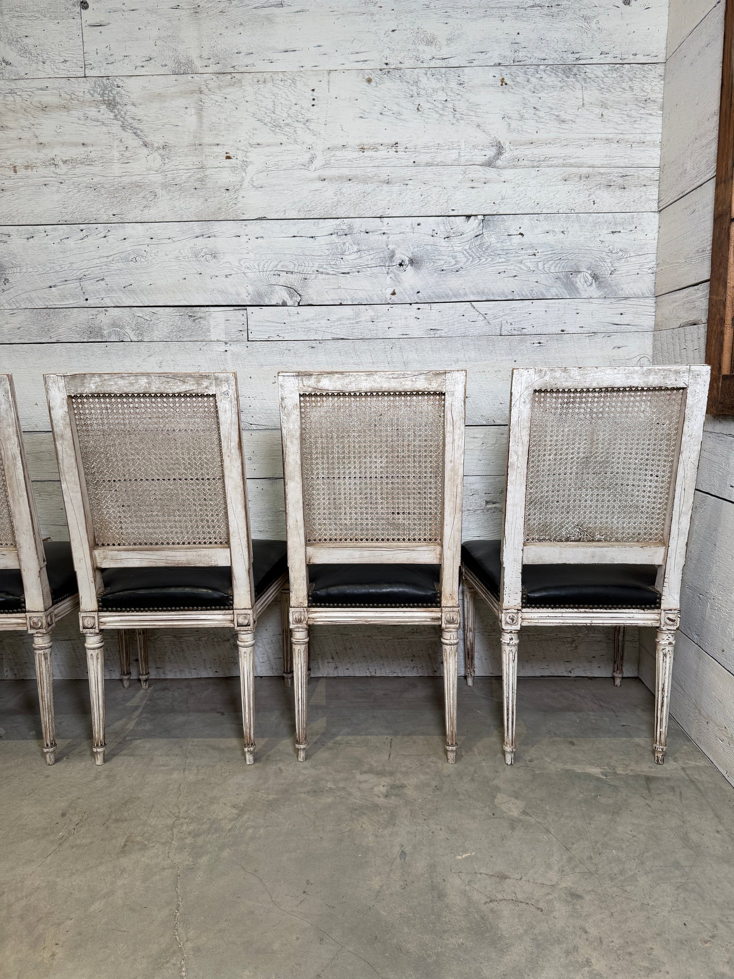 Set of Black Leather and Cane Back Dining Chairs in the Colonial Style