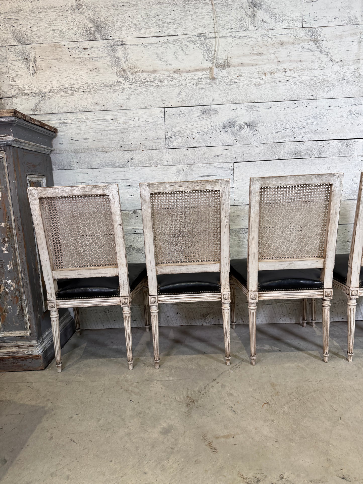 Set of Black Leather and Cane Back Dining Chairs in the Colonial Style