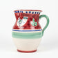 Ceramic pitcher with red, green, and blue patterns on a wooden surface