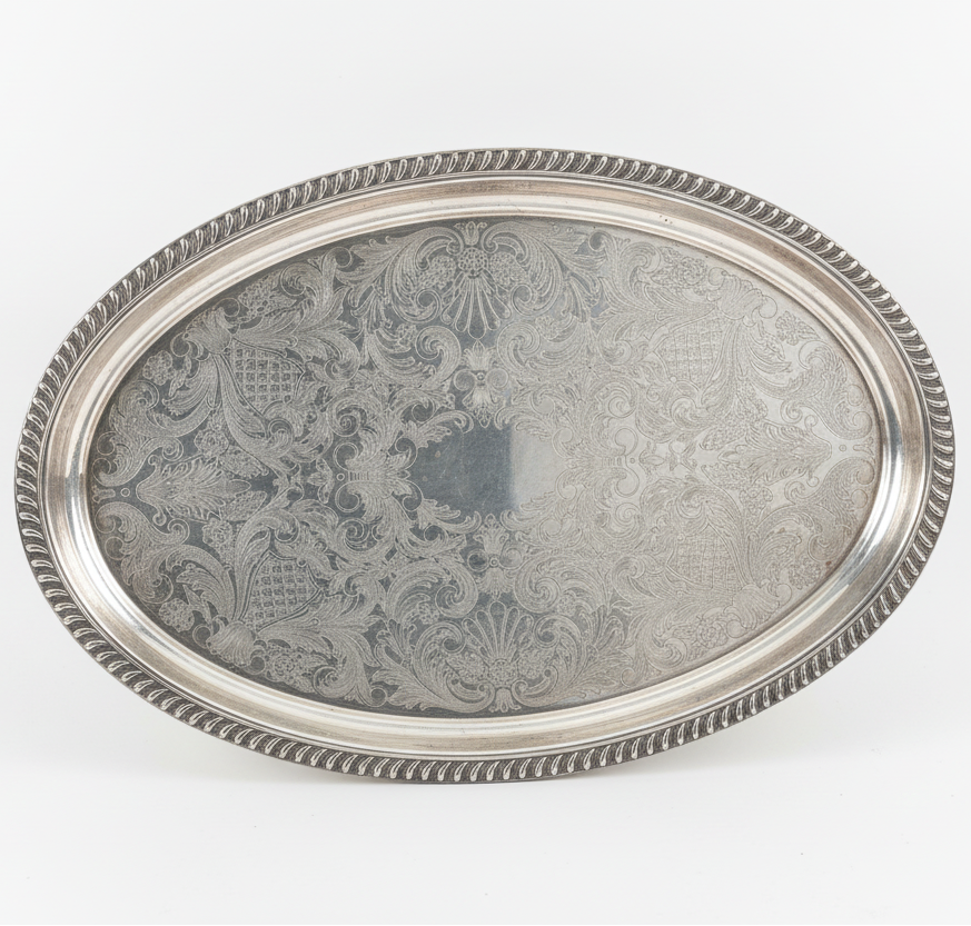 Silver tray with intricate patterns on a white background