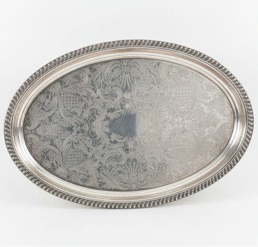 Silver tray with intricate patterns on a white background