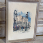 Framed watercolor painting of a city street scene with architecture and people.