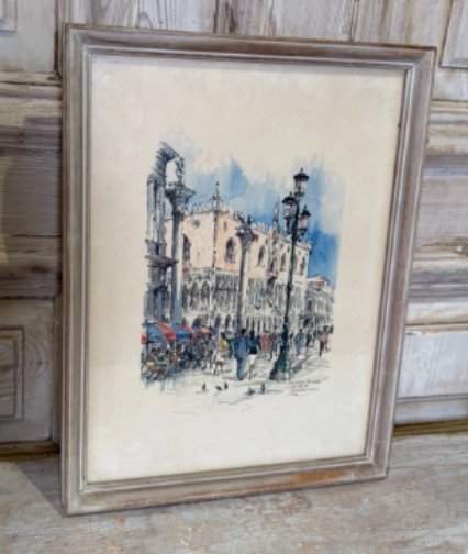 Framed watercolor painting of a city street scene with architecture and people.